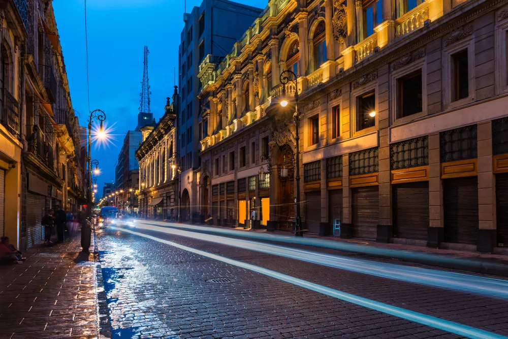 Low exposure photo of the empty stone streets of Mexico City pictured with a car driving by