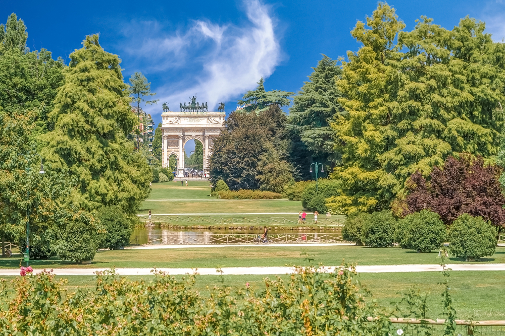 On a nice blue-sky day, the Arco Della Pace in Sempione, one of Milan's best places to stay, is pictured between trees