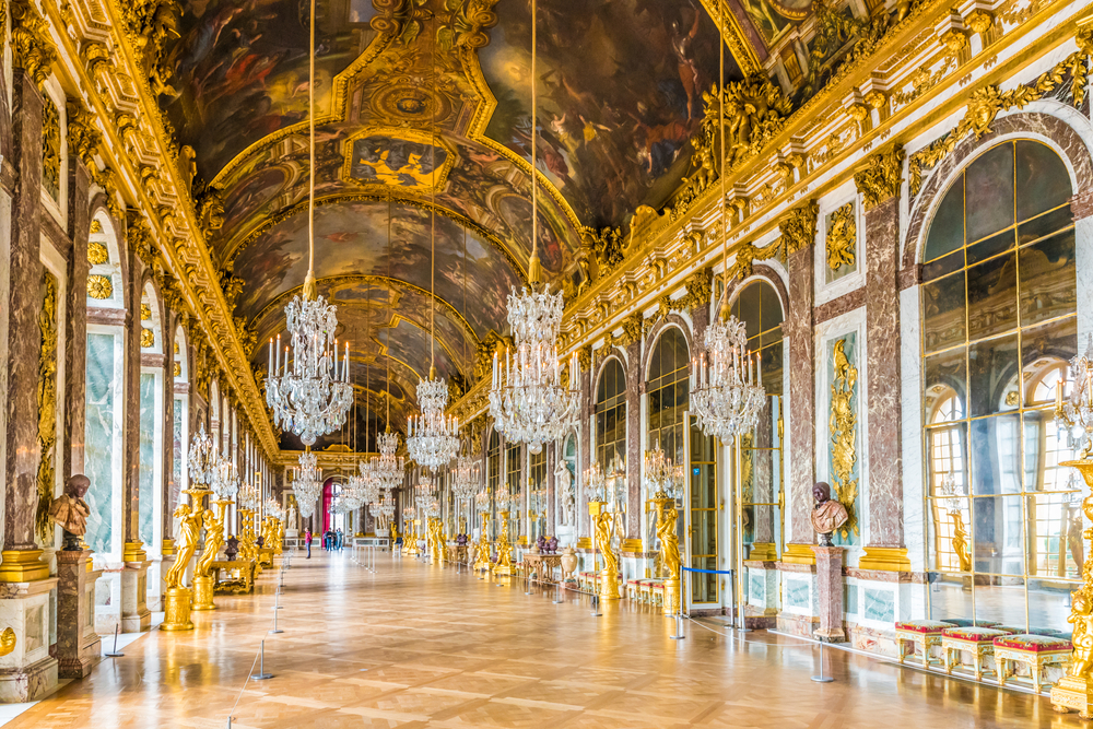 Gorgeous interior view of the Gold and brown palace of Versailles, one of the best places to visit in Paris