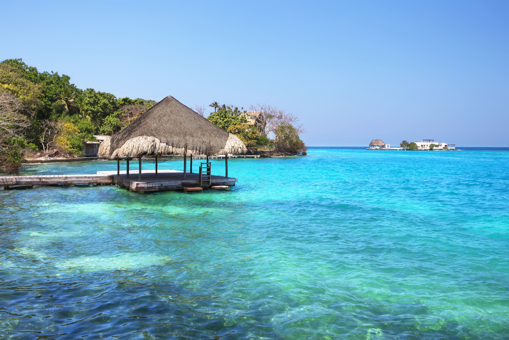Wooden and thatch dock above the teal and blue water in the Rosario Islands, one of Colombia's must-visit places