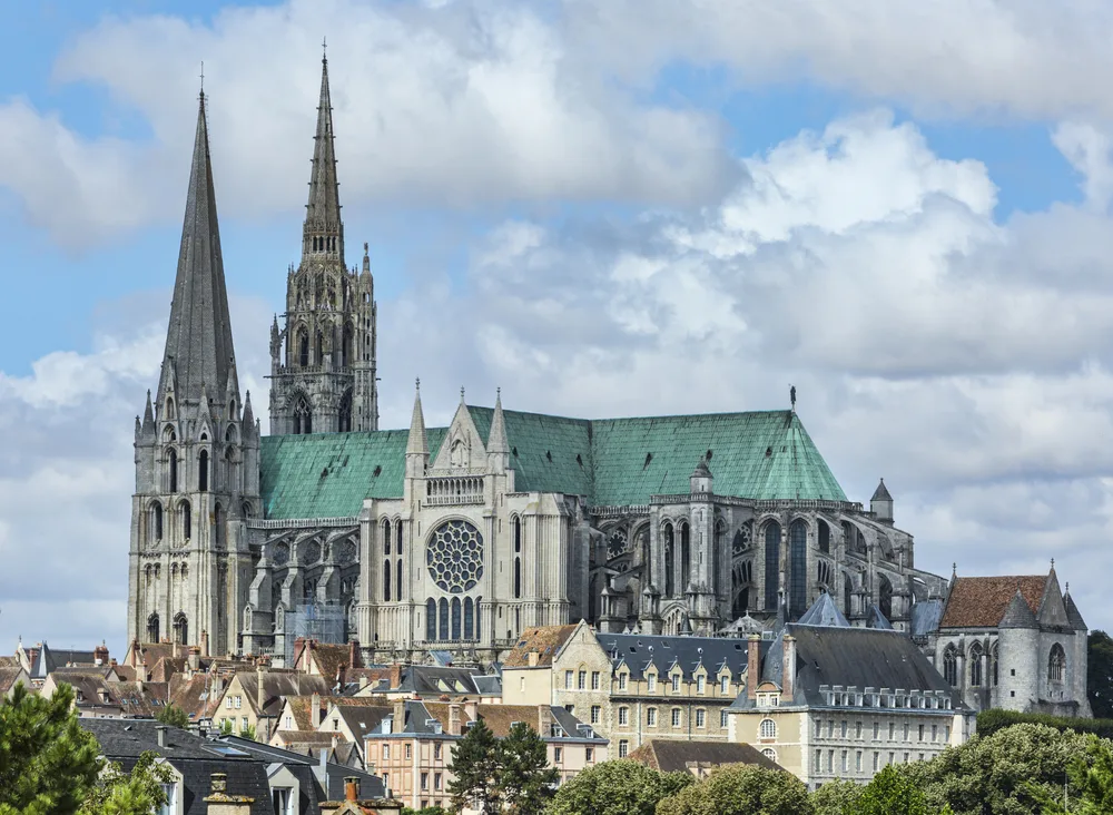 Stunning view of the Chartres Cathedral, one of our top picks for must-visit day trips from Paris, with its grey and green spires and roof jutting into the air