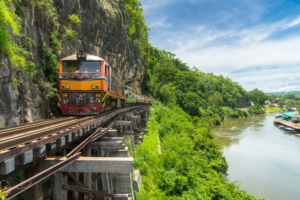 Train on the very edge of tracks that run along an elevated platform in the Kanchanaburi jungle