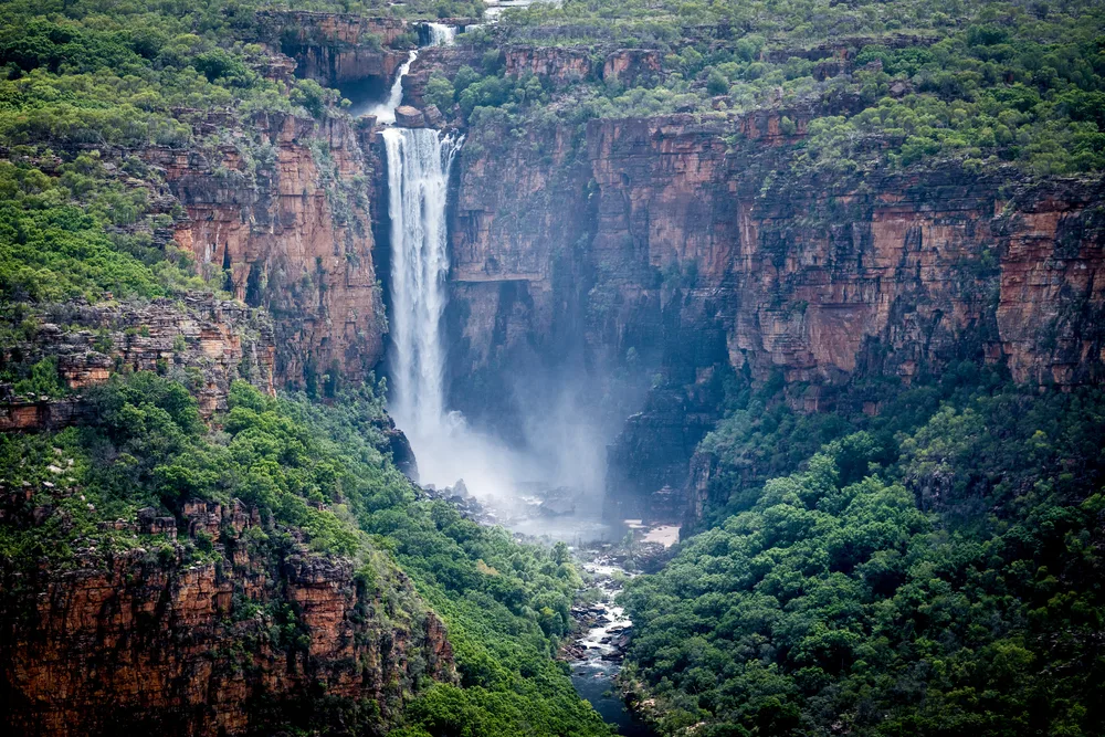 Huge waterfall pouring down into the valley below for a piece on the best places to visit in Australia, Kakadu Park