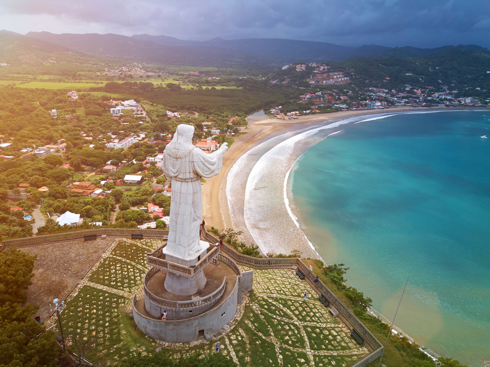 Jesus statue towering over the beach and water below in one of the best places to visit in Central America, San Juan del Sur, Nicaragua