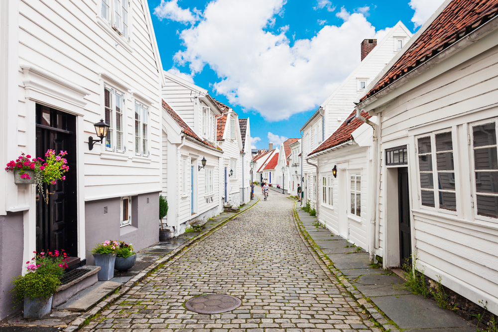Little white homes lining a cobblestone street in Stavanger, a must-visit place in Norway