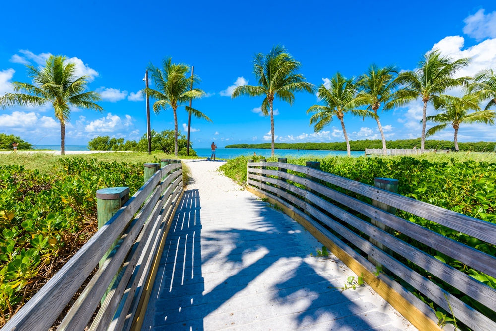 Sombrero Beach in Marathon shows palm trees and a walkway to the beach on one of the best islands in the Florida Keys