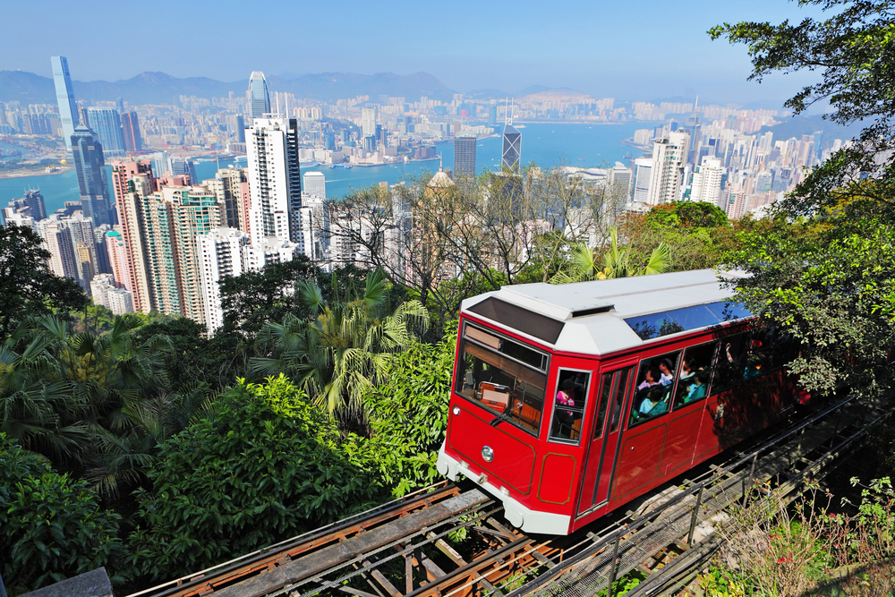 Red tourist tram making its way high above the downtown skyline of Hong Kong