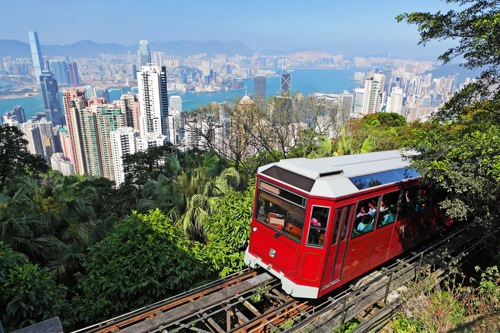 Red tourist tram making its way high above the downtown skyline of Hong Kong