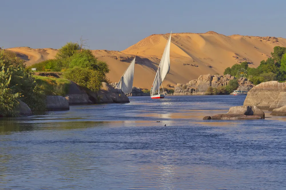 Cool view of a couple sailboats making their way up the Nile River for a roundup of the must-visit places in Egypt