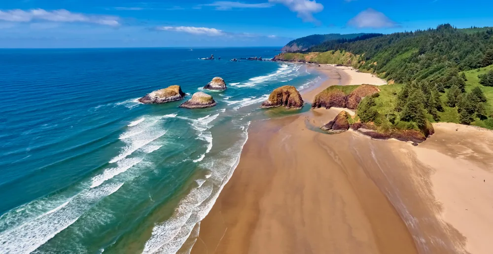 Aerial view of waves crashing on Cannon Beach toward Ecola State Park in Oregon, listed as one of the best beaches in the USA