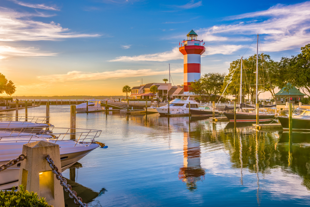 Boats in the marina in one of South Carolina's best places to visit, Hilton Head, with its red and white lighthouse