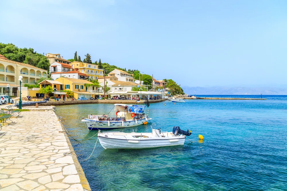 To illustrate one of the best parts of Corfu, two small boats float on the water in Kassiopi Bay
