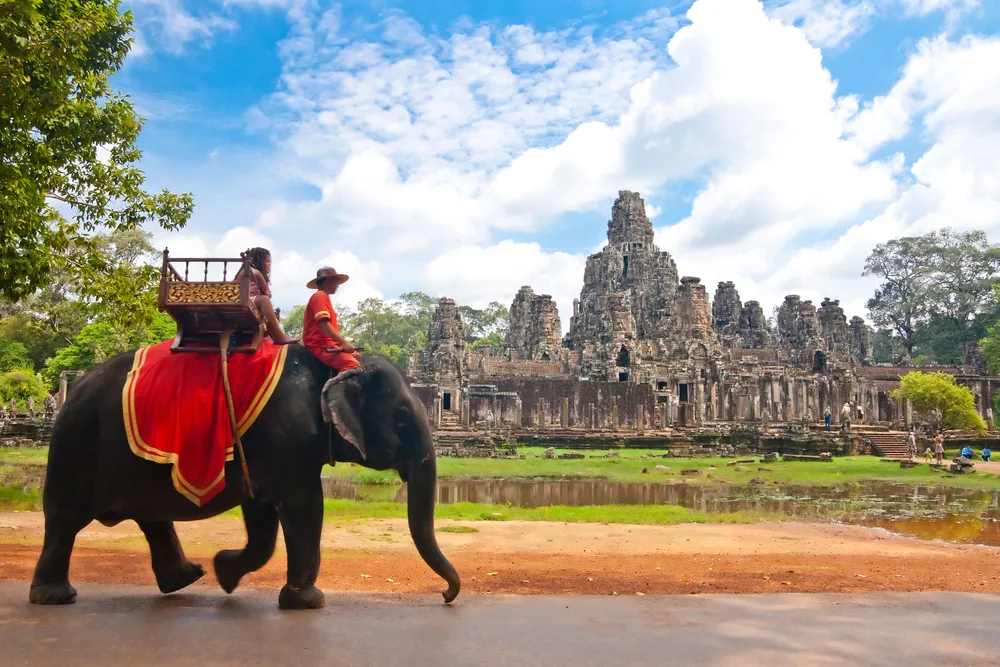 Guy riding an elephant just outside of the Siem Reap temple during the best time to travel to Cambodia
