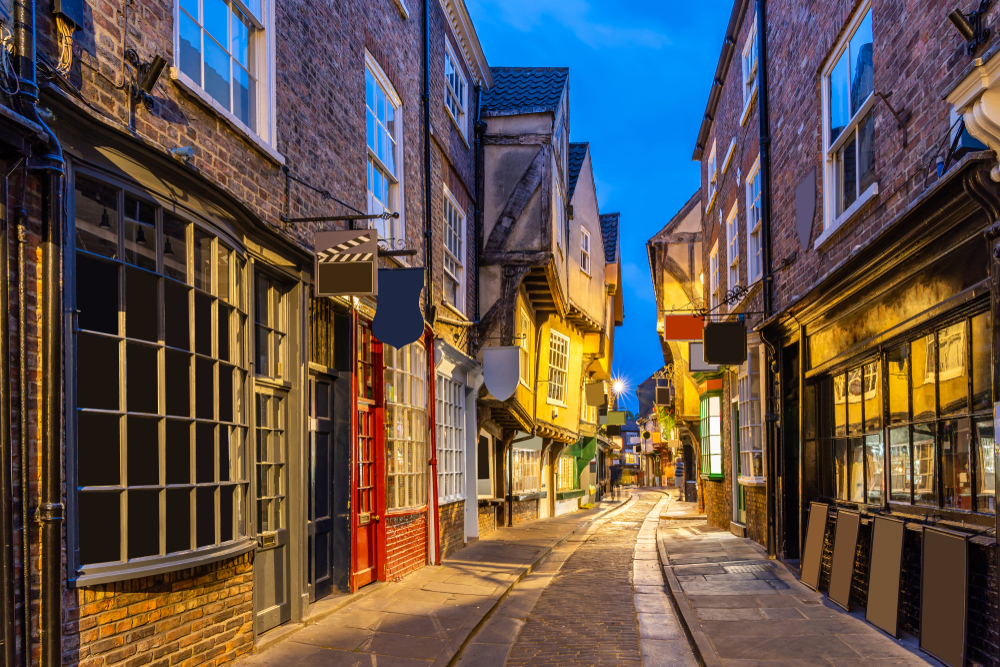 Dark alley with a stone path in the middle of a Diagon Alley-like area in York