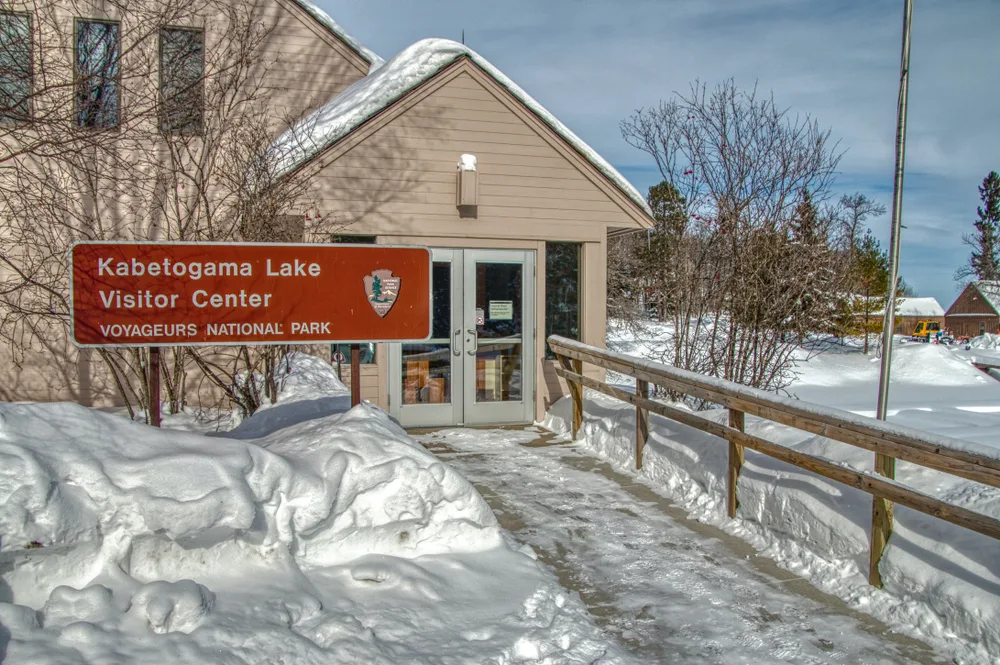 Photo of the Kabetogama Lake Visitor Center at Voyageurs National Park pictured below blue sky in the winter, the overall worst time to visit Voyageurs National Park