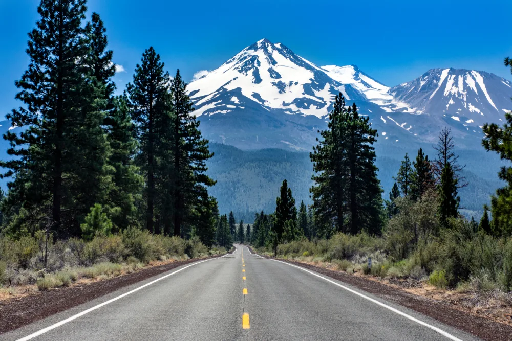 Mt. Shasta in the distance capped with snow along a rural highway showing one of the best places to visit in February