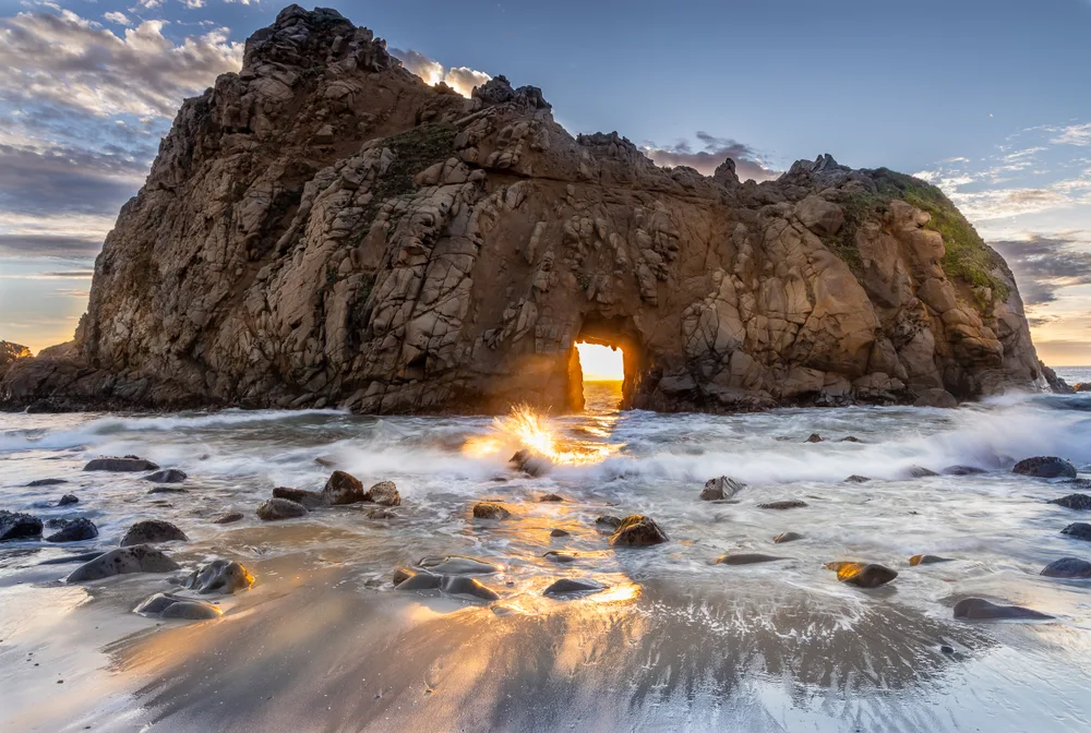 Sun Portal keyhole rock at Pfeiffer Beach in Big Sur California at sunset to show features of one of the best beaches in the USA