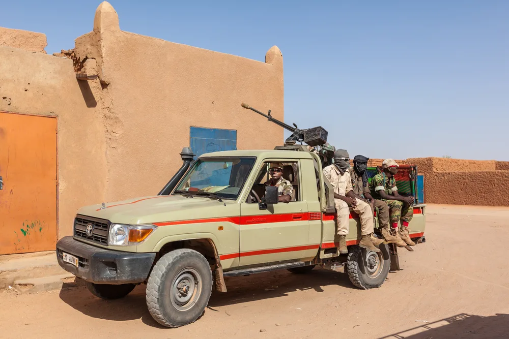 Ingall, Niger is pictured with several guards sitting on a tan truck for a piece on is Chad safe to visit