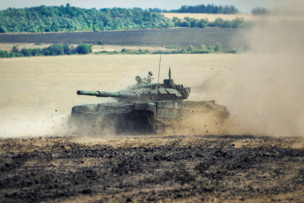 Russian battle tank moving along a muddy field to illustrate that Russia is not safe to visit now