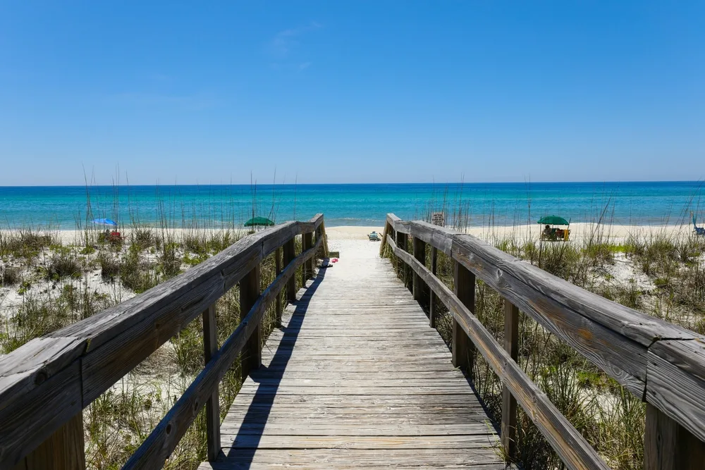 Henderson Beach State Park in Destin with a wooden boardwalk leading up to the shore on a clear day 