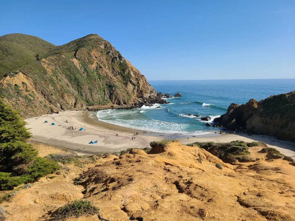 Aerial view of rocky and sandy Pfeiffer Beach in Big Sur taken from the hills on a clear day to highlight one of the best Californian beaches overall