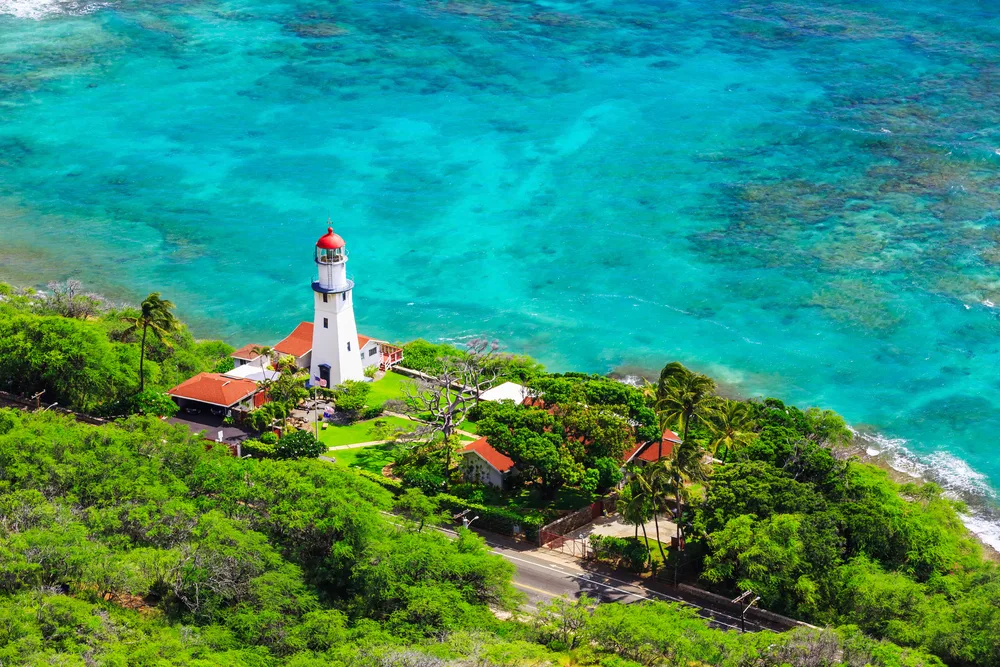 Aerial view of Diamond Head Lighthouse with blue water and greenery around it during the best time to visit Honolulu