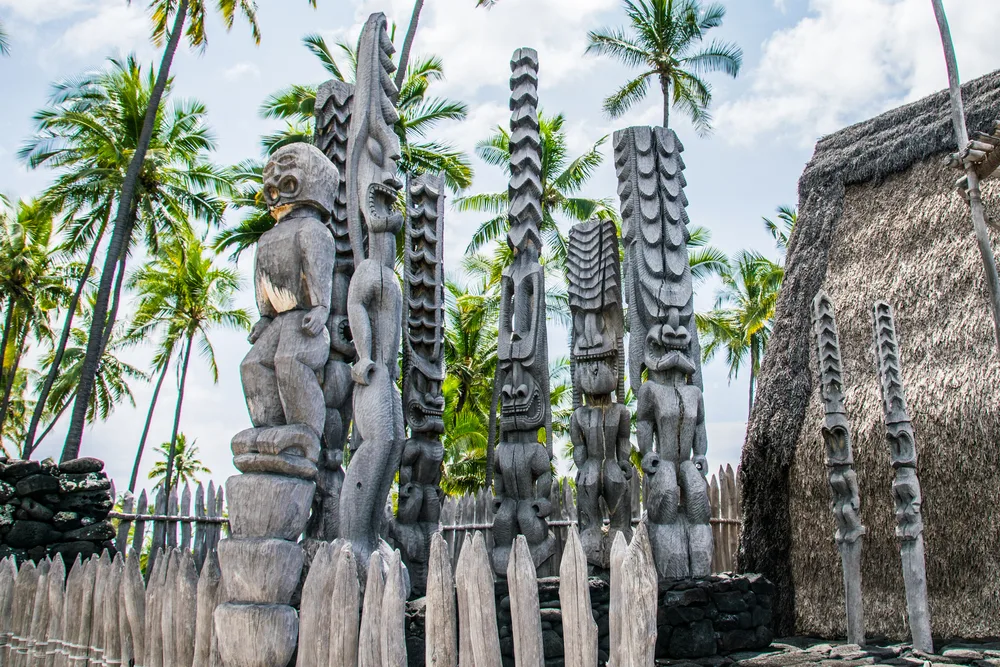 Wooden tiki carvings at Ki'i Pu'uhonua O Honaunau National Park during the best time to visit Kona 