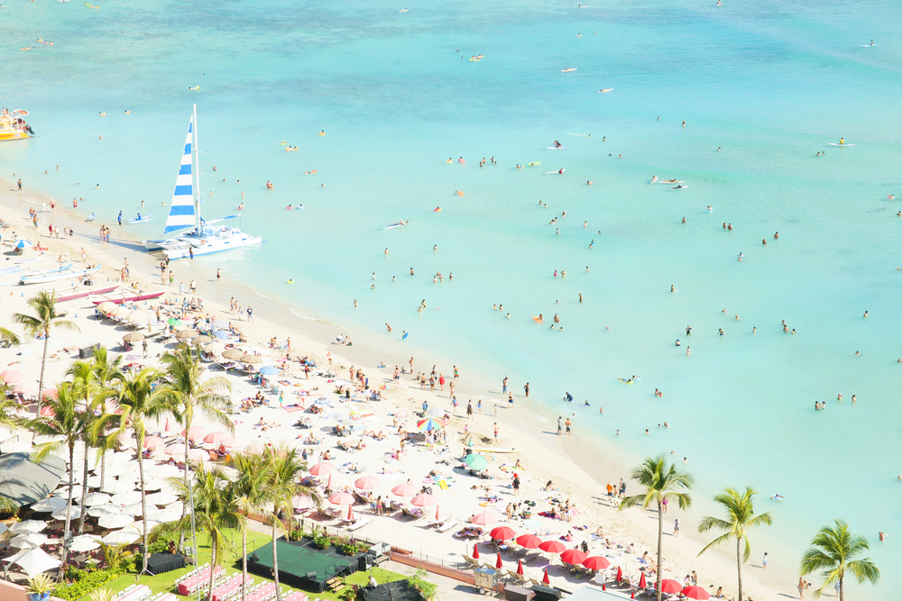 A crowded aerial view of Waikiki Beach during what may be the worst time to visit Honolulu in the winter peak season