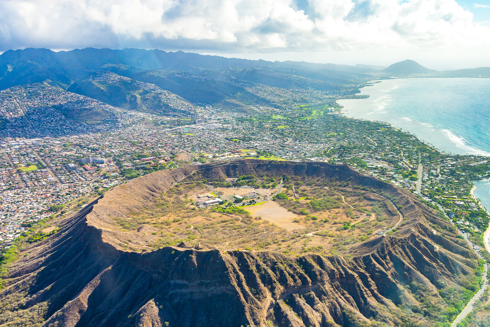 Aerial view of the Diamond Head crater with the city skyline in the background during the best time to visit Honolulu