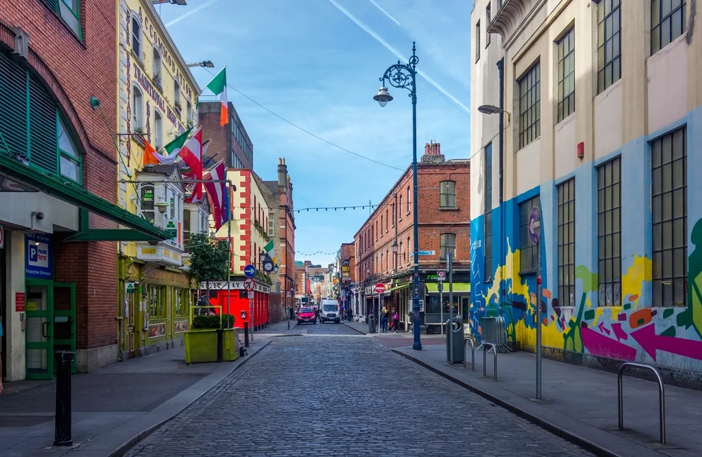 Colorful streets of Dublin pictured with shadows over the buildings and lights strung along the lightpoles