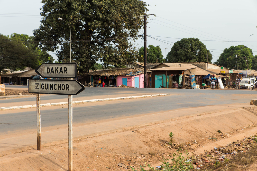 For a piece titled Is Senegal Safe to Visit, a sign points to Dakar and Ziguinchor