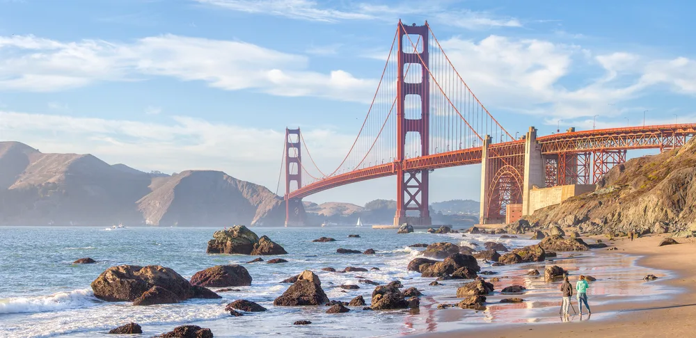 Panoramic view of the Golden Gate Bridge from rocky Baker Beach in San Francisco on a cloudy day to show one of the best beaches in California