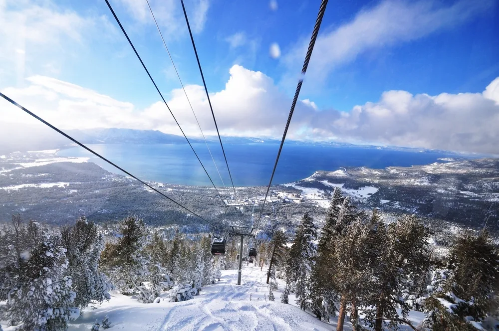 To help answer Is Lake Tahoe Safe to Visit, a POV of a skiier on a lift looking down toward the valley
