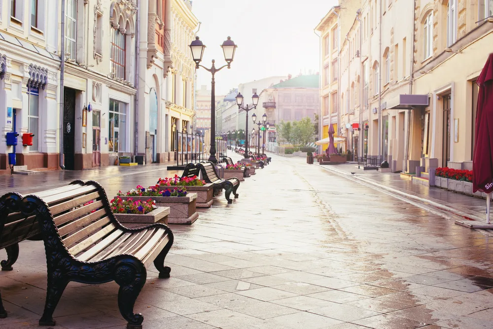Rainy day in Moscow pictured with a park bench along the street