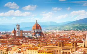 Aerial view of Santa Maria del Fiore among the Florence skyline in front of the Apennine Mountains during the best time to visit Florence in early summer