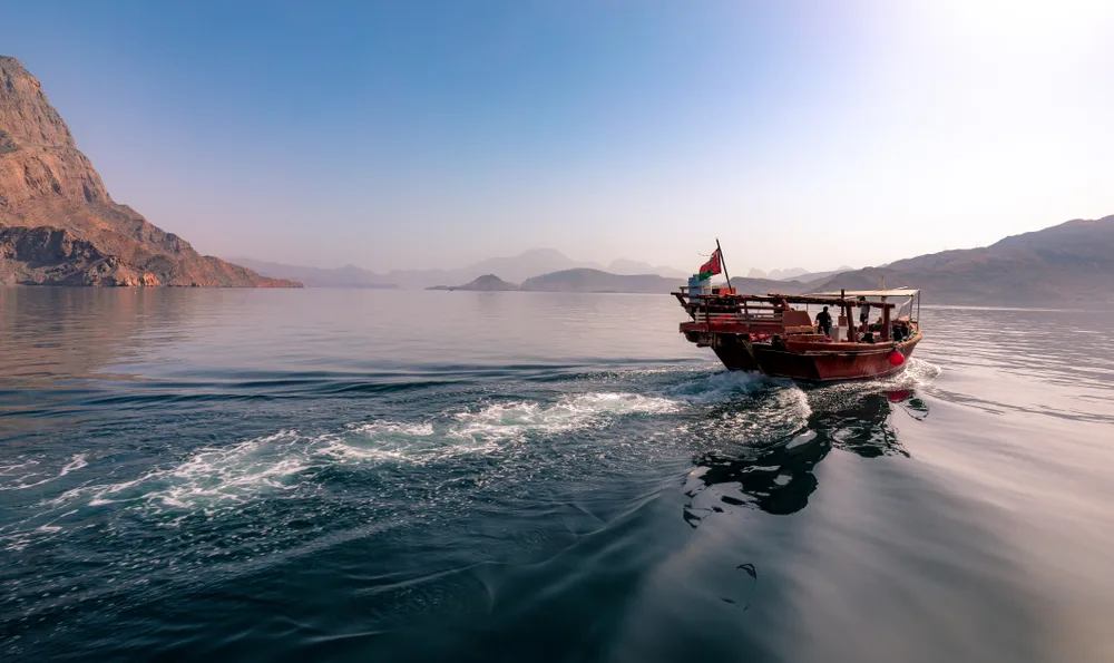 Neat wooden boat cruising down the fjords in Musandam Oman