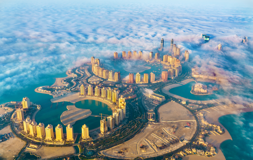 Aerial view through clouds over Pearl-Qatar island to indicate why you should visit Qatar