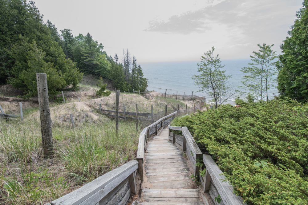 Picturesque photo of White Dunes State Park with its cliffside boardwalk running along the scenic overlook on the hillside