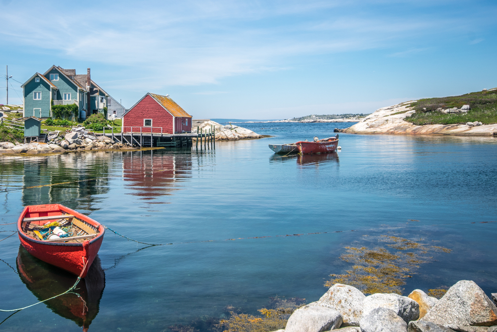 Photo of boats floating on the water of Peggy's Cove pictured during the overall cheapest time to visit Nova Scotia