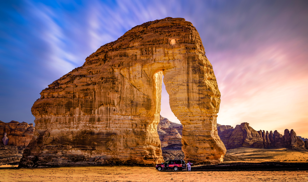 Elephant Rock at sunset with colorful sky as a car passes in front for a frequently asked questions section on the best time to visit Saudi Arabia 