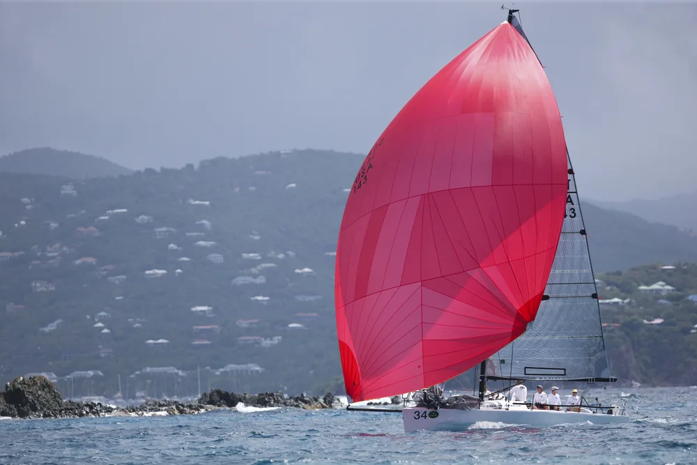 Giant red sail on a boat pictured in March during the best time to go to St. John's Island during the Regatta