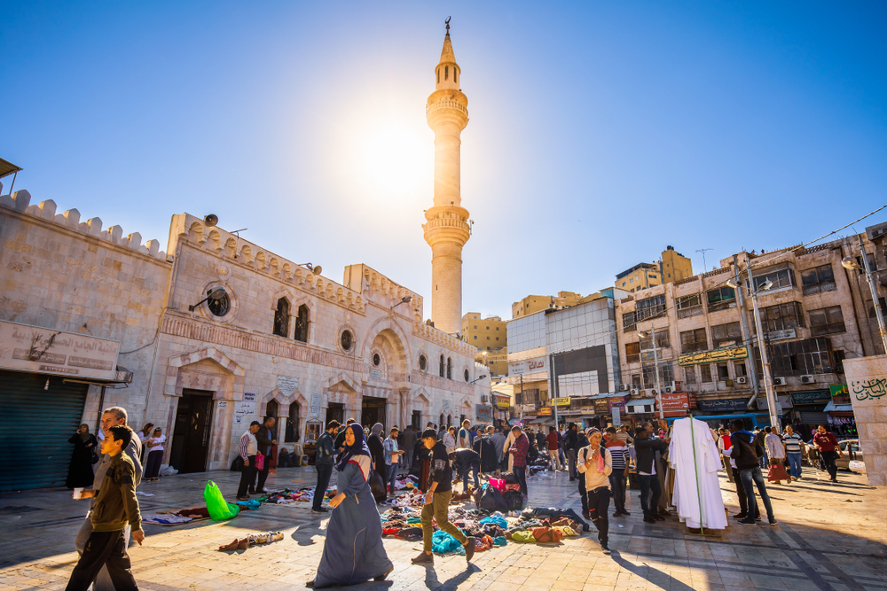 People mulling about in the courtyard of the Husseini Mosque in Amman for a guide to the best and worst times to visit Jordan
