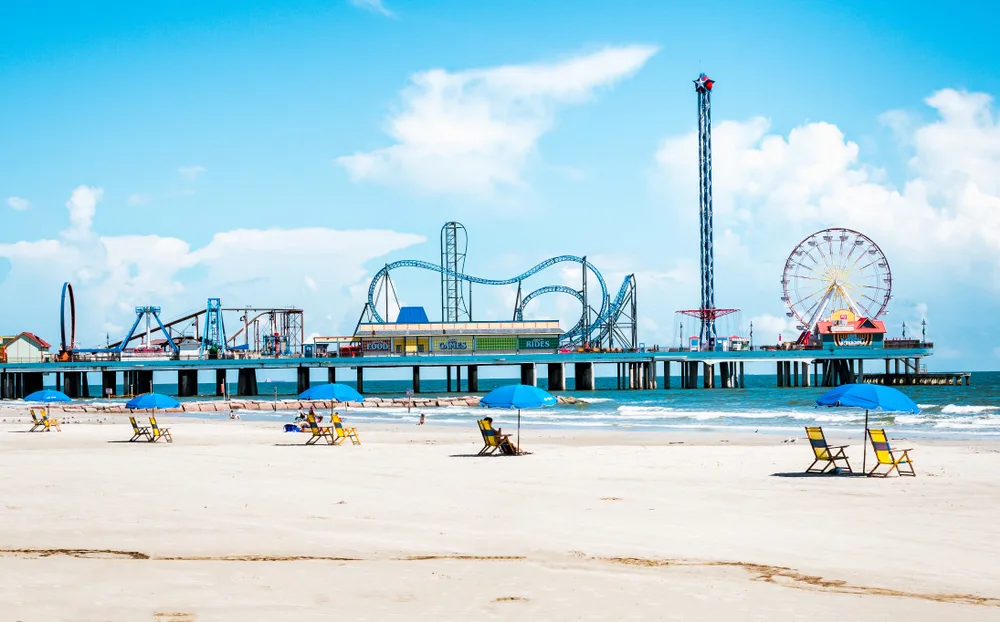 Galveston Island Seawall Beach with the Pleasure Pier amusement park in the background shown as one of the best beaches in Texas on a nice day during summer