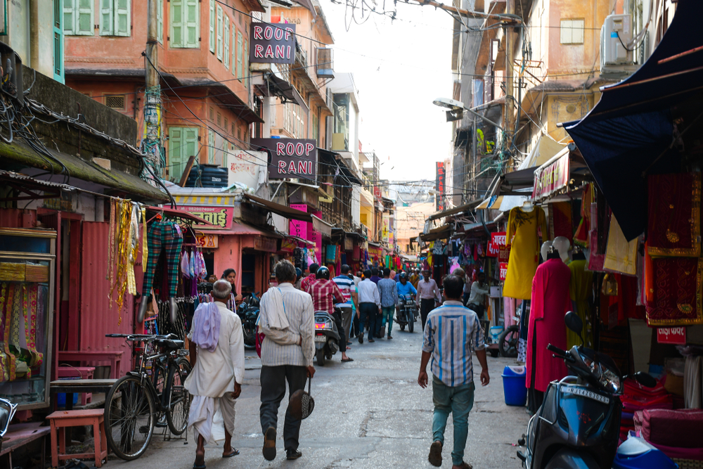 People walking along the street holding their belongings and shopping for clothes and other wares in Jaipur for a guide to whether or not India is safe to visit