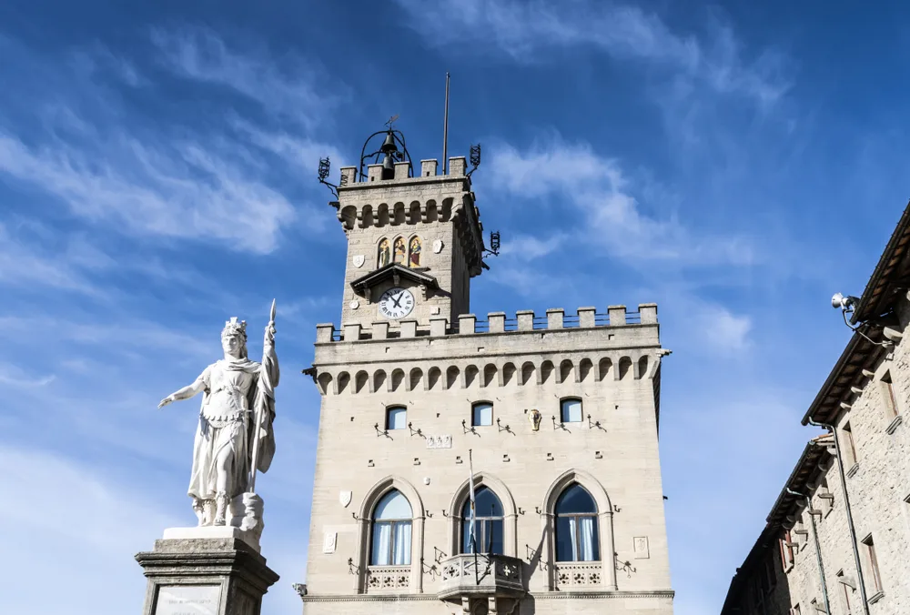 Palazzo Pubblico with the Statua della Libert pictured in front on a clear day during the summer for a frequently asked questions section about the best time to visit San Marino