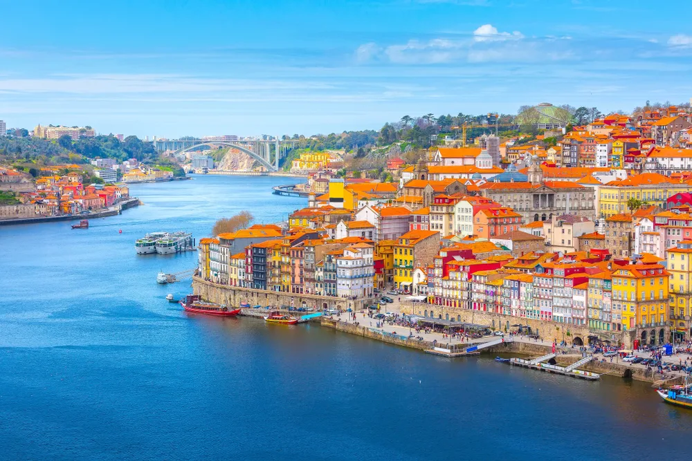 A sunny, clear summer day in Ribeira during the overall best time to visit Porto with colorful houses close together along the river
