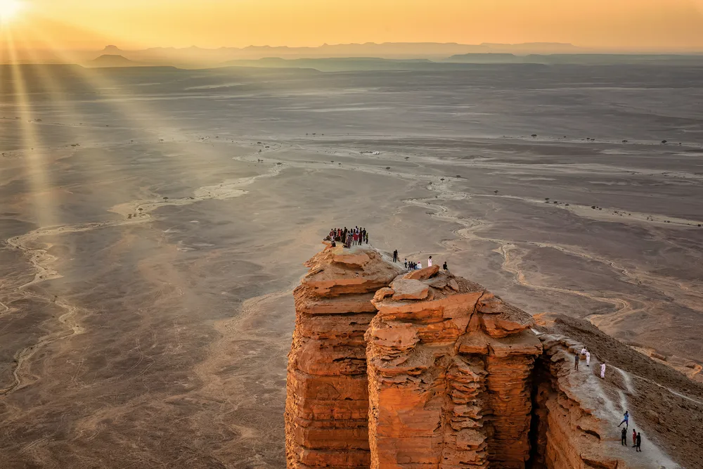 Sun rays hit the cliffs at the Edge of the World outside of Riyadh during fall and winter, the best time to visit Saudi Arabia