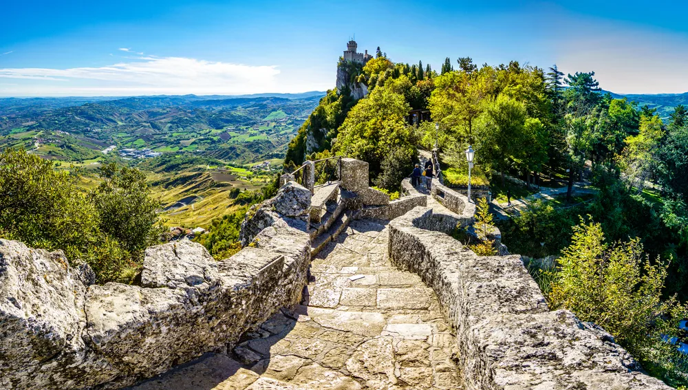Stone path around the first historic fortress tower during the warm summer season, the best time to visit San Marino