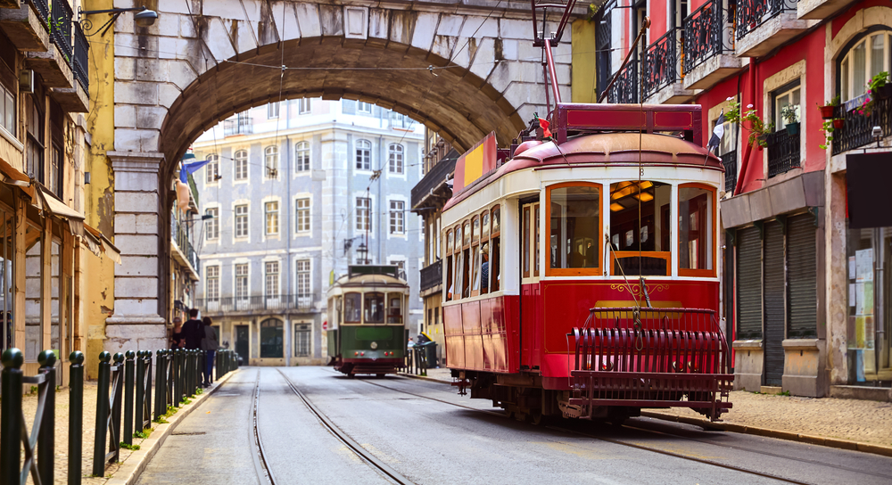 Vintage tram in one of Lisbon's best areas to stay, Alfama, with its historic old buildings