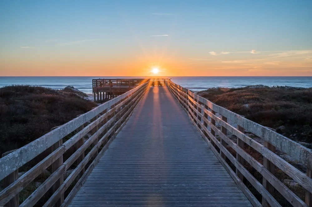 Sunrise on Malaquite Beach on North Padre Island with boardwalk leading to the ocean shows one of the best beaches in Texas for seclusion, space, and relaxation